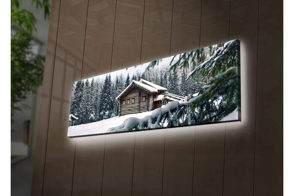 Lerretsbilde med LED-belysning 30x90 cm - Vinterlandskap med hytte omgitt av snø og grantrær v:1415391